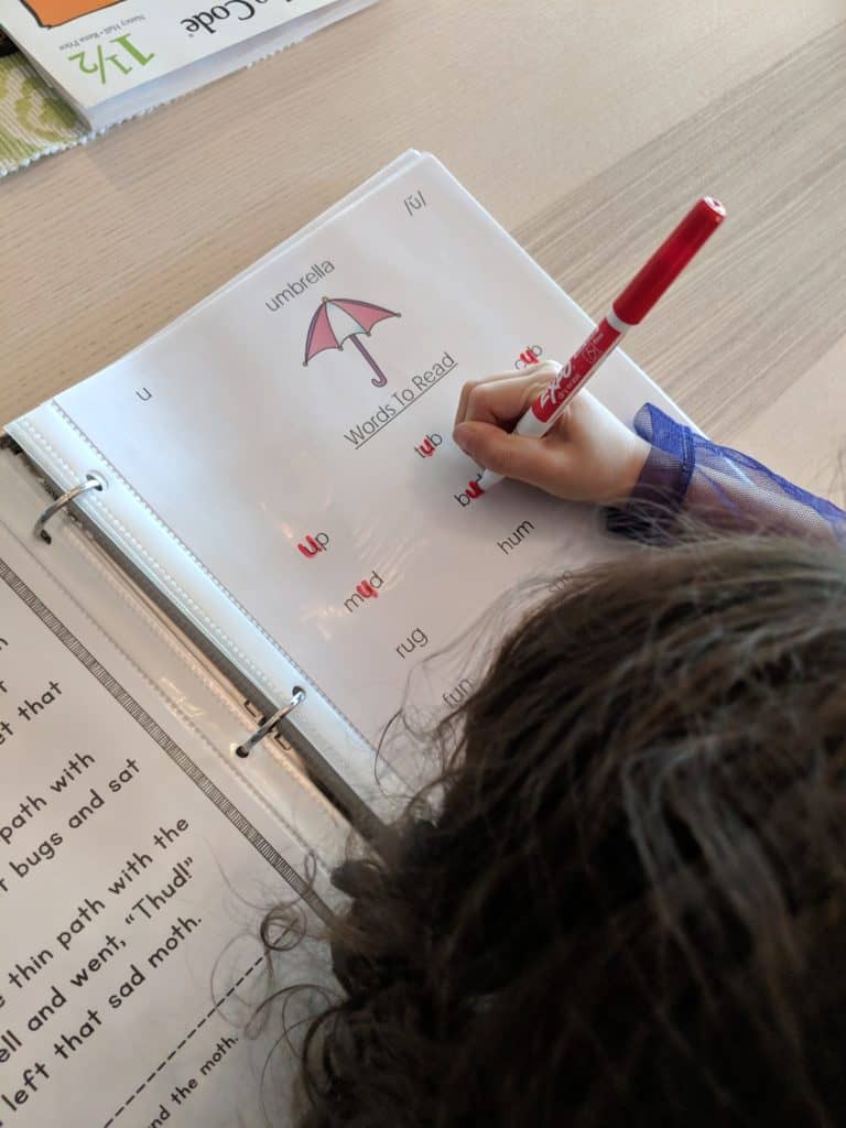 multisensory writing activity - girl tracing letters on a page